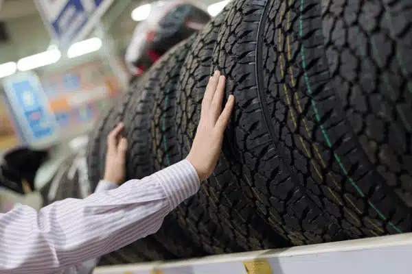 Hands compare tread patterns on display tires inside tire shops in Waco choosing replacements for driving