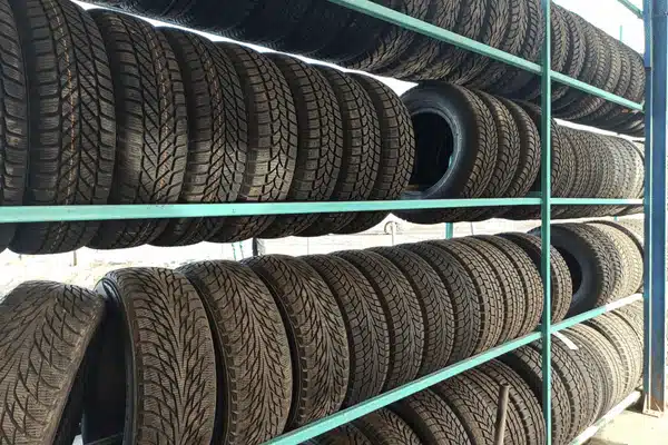 Rows of stored tires on metal racks show inventory at used tire shop warehouse
