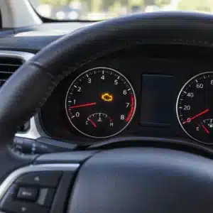 The glowing engine-shaped warning on the dashboard shows the check engine light meaning inside a modern vehicle